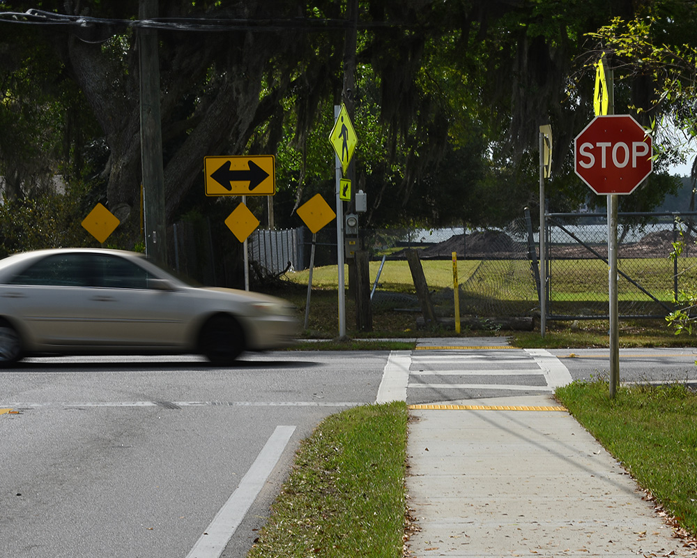 car driving by crosswalk