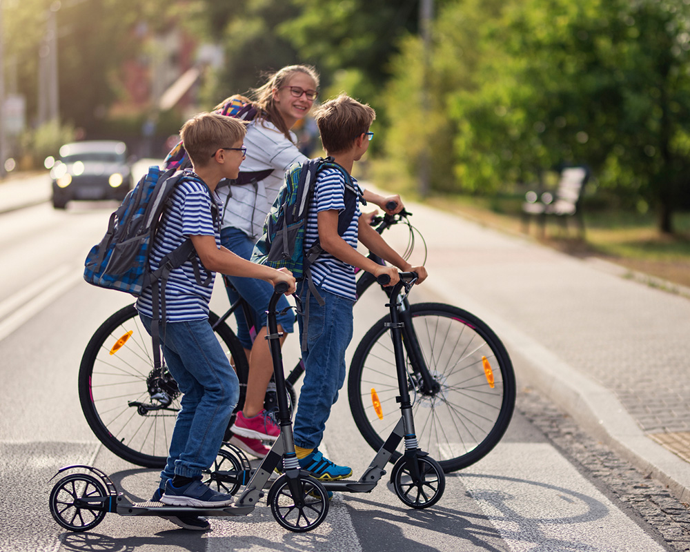 children crossing street on bikes and scooters