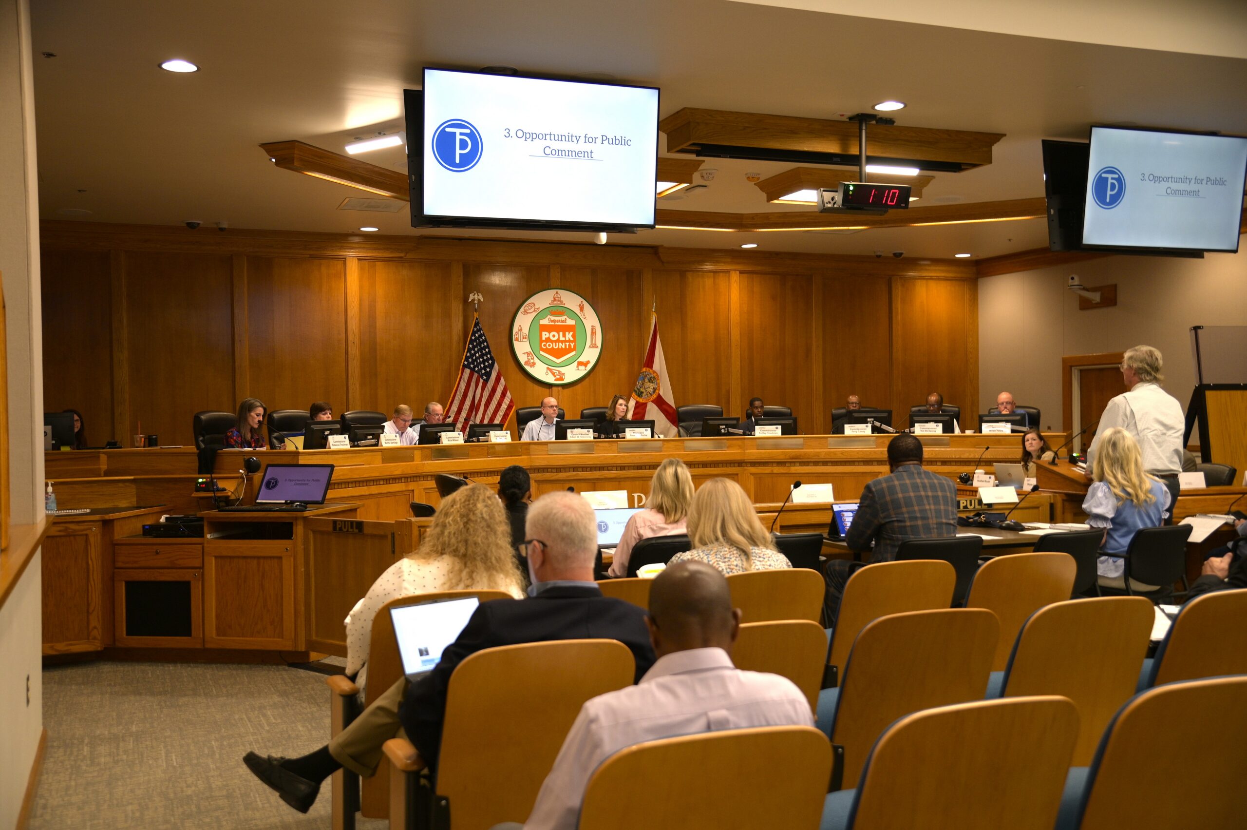 A Polk TPO Board meeting in progress, with board members at the dais and a resident speaking during the public comment period.