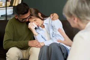 A distraught woman wipes away tears while being comforted by a partner after loss of a loved one after a traffic crash, highlighting the emotional impact of roadway safety on Polk County roads.